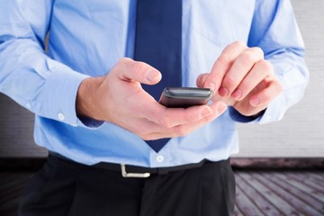Poster - Composite image of close up of a businessman using a smartphone