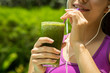 Athletic girl holding a green smoothie