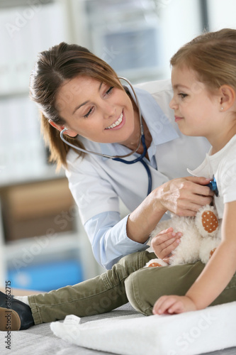 Naklejka dekoracyjna Doctor examining little girl with stethoscope