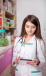 © DC Studio - Young female doctor in pharmacy with digital tablet in hands