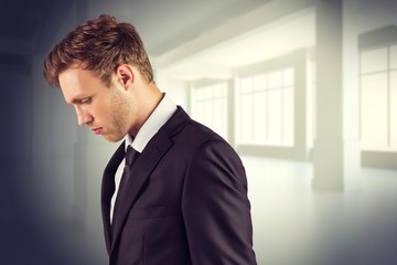 Poster - Composite image of young handsome businessman looking down