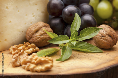 Foto-Lamellenvorhang - Organic walnuts, grapes and hard cheese on wood (von artfood)