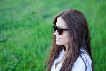 Wall Mural - Pensive cool girl with brackets and sunglasses outside