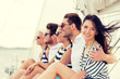 © Syda Productions - smiling friends sitting on yacht deck