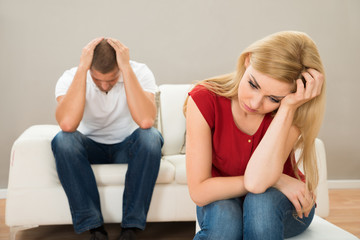 Man On Sofa Looking At Stressed Woman