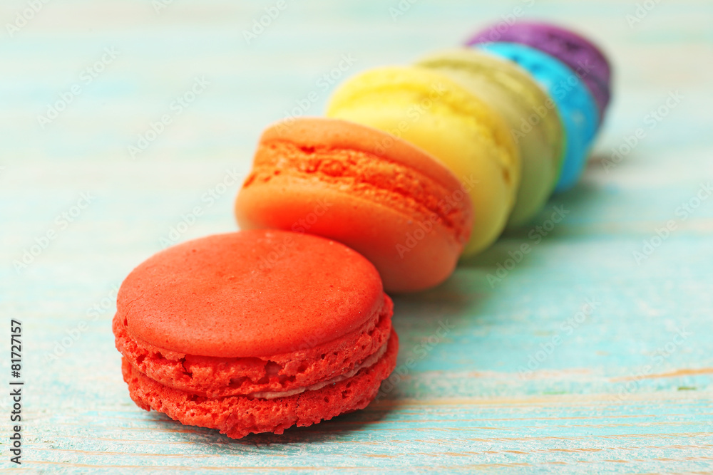 Tasty colorful macaroons on color wooden background