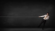 © ra2 studio - Businessman pulling rope on grey background