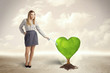 © ra2 studio - Business woman watering heart shaped green tree