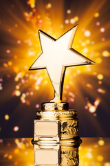 Wall Mural - gold star trophy against shiny sparks background