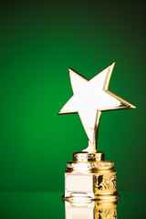 Wall Mural - gold star trophy against green background