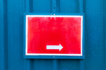 Reflective red notice board showing direction mounted on metal b