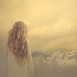 © VectorART - girl in a dress stands in the clouds over the mountains