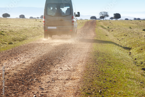Fotografie, Obraz Dirty road in a mediterranean meadow with minibus. Cabeneros. Sp