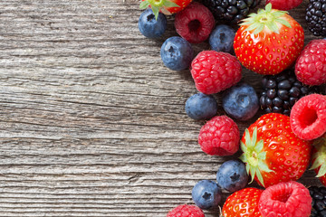 wooden background with fresh berries, top view