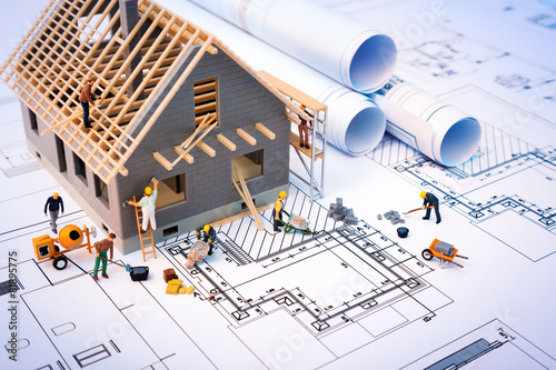 Fotografía La construcción de la casa en planos con trabajador - proyecto de construcción