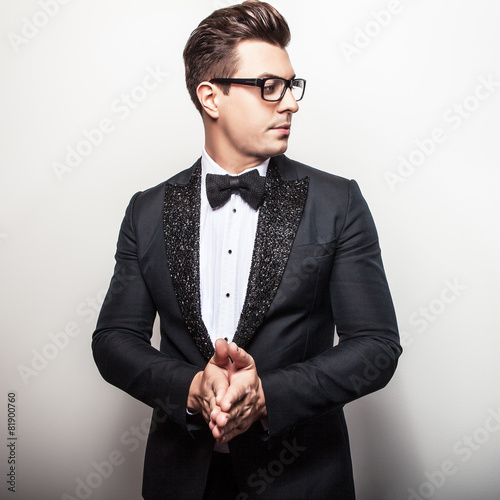 Fototapeta na wymiar Elegant young handsome man in black luxury costume.