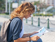 young woman with a city map and a backpack