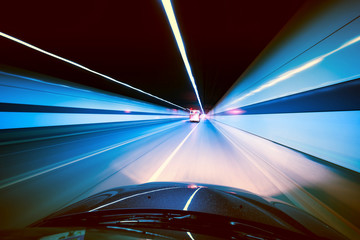 Wall Mural - Speeding car inside a highway tunnel exiting to white calm light