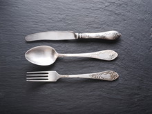 Silver Cutlery On A Dark Grey Background.