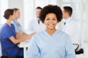 Poster - happy doctor over group of medics at hospital