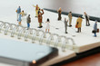 © everythingpossible - close up of miniature people with social network diagram on open