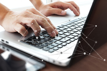 Close up of business man working on laptop computer with social