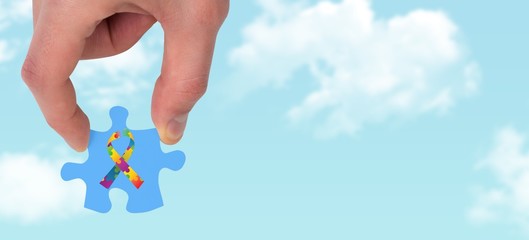 Poster - Composite image of hand holding jigsaw piece
