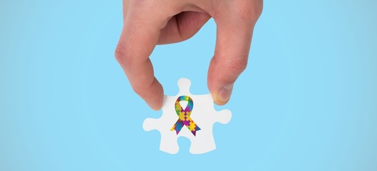 Poster - Composite image of hand holding jigsaw piece