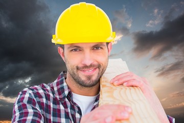 Poster - Composite image of handyman holding wood planks