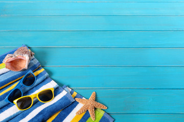 Wall Mural - Beach background summer vacation holiday with sunglasses accessories on old blue wood planked decking space for copy text photo