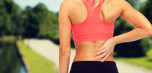 Poster - close up of sporty woman touching her back