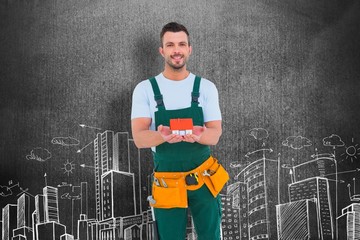 Poster - Composite image of happy construction worker holding house model