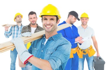 Poster - Composite image of happy carpenter carrying wooden planks