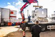 Crane truck lifting heavy CNC machine with hydraulic arm