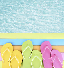 Wall Mural - Female flip flops on wooden platform beside sea