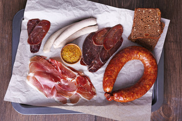 Poster - Assortment of deli meats on parchment on wooden table background