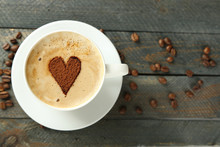 Cup Of Cappuccino With Heart Of Cocoa On Wooden Table