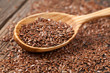 Heap of flax seeds in vintage wooden spoon
