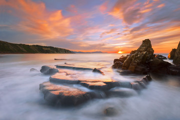 rock in Azkorri beach at sunset