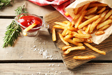 Tasty French Fries On Cutting Board, On Wooden Table Background