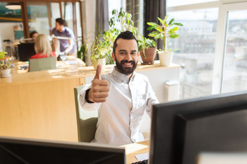 Wall Mural - happy male office worker showing thumbs up