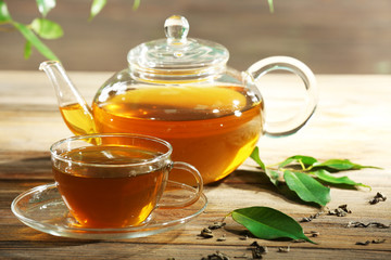 Wall Mural - Cups of green tea on table on green background