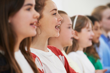 Group Of School Children Singing In Choir Together