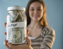 Hispanic Girl Holding ,'college' Savings Jar