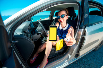 Woman showing phone screen in the car