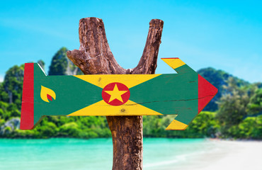 Wall Mural - Grenada Flag wooden sign with beach background