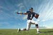 © Pete Saloutos/Blend Images - African American football player poised on field