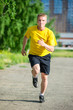 © mr.markin - Sporty man jogging in city street park. Outdoor fitness.