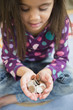 © JGI/Jamie Grill/Blend Images - Hispanic girl holding handful of coins