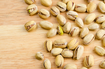 roasted and salted pistachios on wooden background